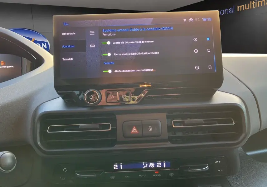 Vue rapprochée du tableau de bord du Peugeot Rifter gris acier 2025, avec écran tactile affichant les aides à la conduite.