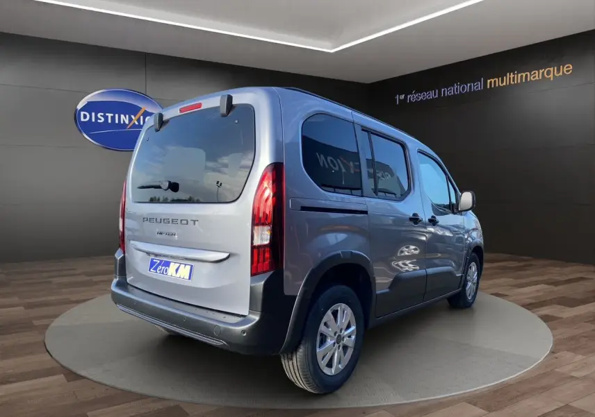 Peugeot Rifter gris acier vue 3/4 arrière droit, vitres surteintées et hayon avec lunette ouvrable.