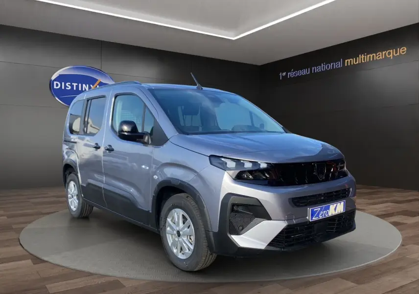 Peugeot Rifter gris acier en vue 3/4 avant droit, avec jantes alliage et calandre noire distinctive.