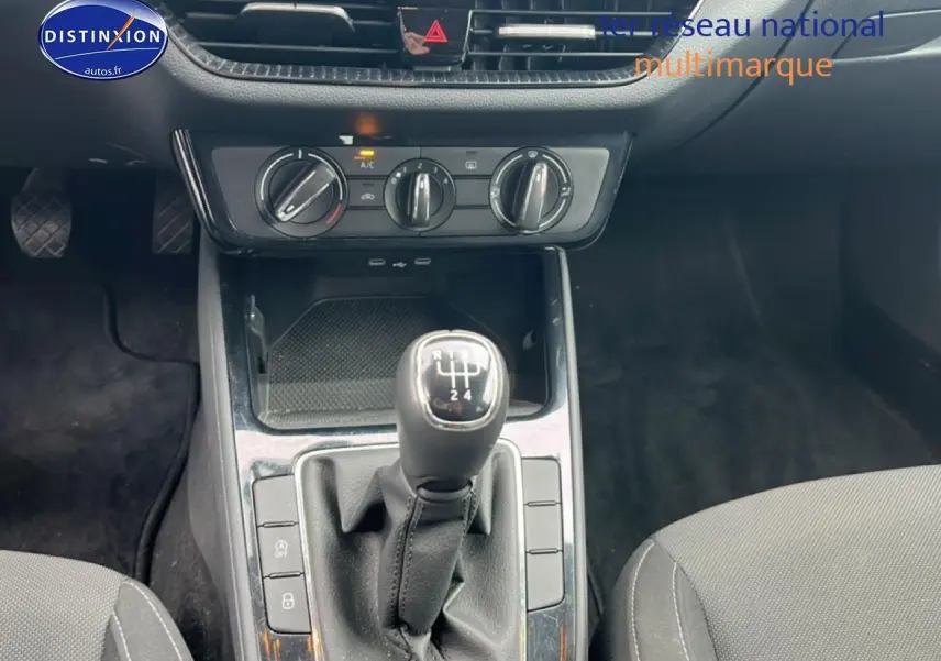 Vue rapprochée de la console centrale d’une Skoda Fabia blanche 2025 avec levier de vitesse manuel et commandes climatisation.