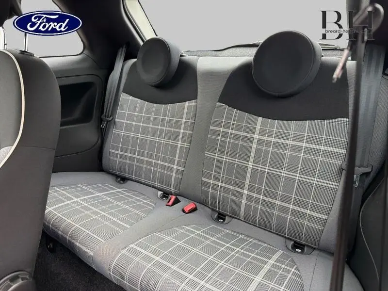 Vue intérieure arrière de la banquette grise à motif écossais d'une Fiat 500 blanche, avec appuie-têtes ronds.