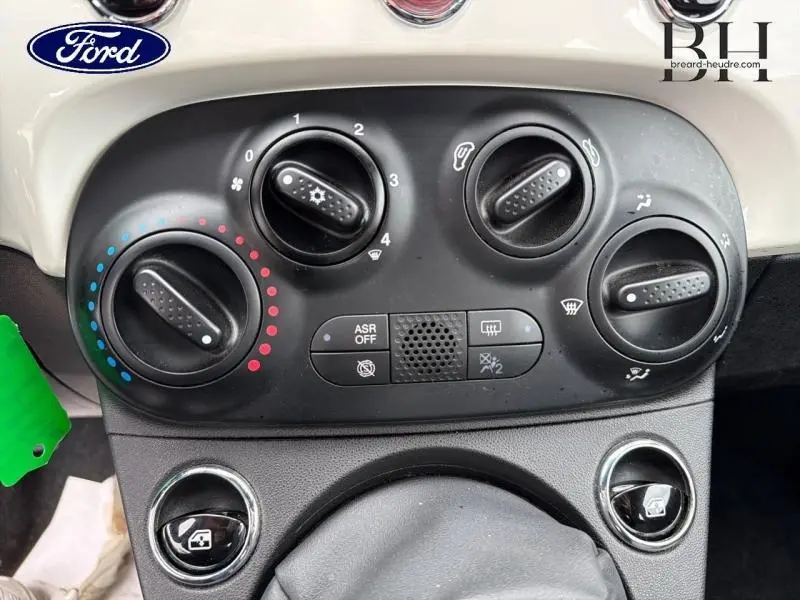 Vue rapprochée des commandes de climatisation et ventilation noires sur tableau de bord blanc Bossa Nova White Pastel d'une Fiat 500.