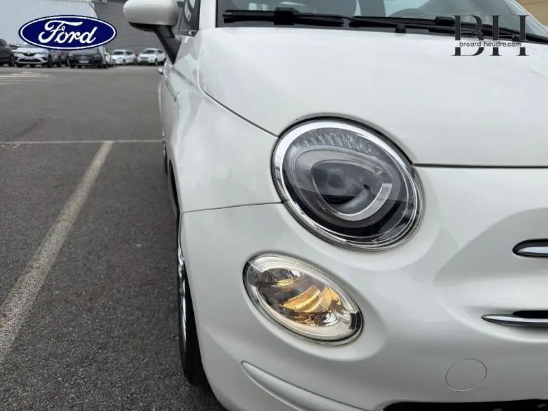 Gros plan sur l'avant gauche de la Fiat 500 blanche Bossa Nova avec phares ronds et calandre chromée.