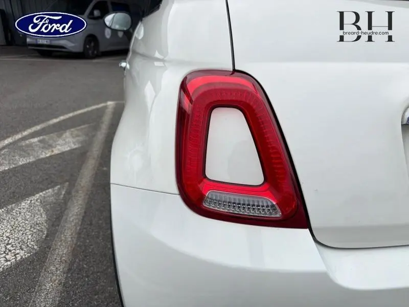 Gros plan sur le feu arrière gauche de la FIAT 500 blanche Bossa Nova White Pastel, avec partie arrière visible.