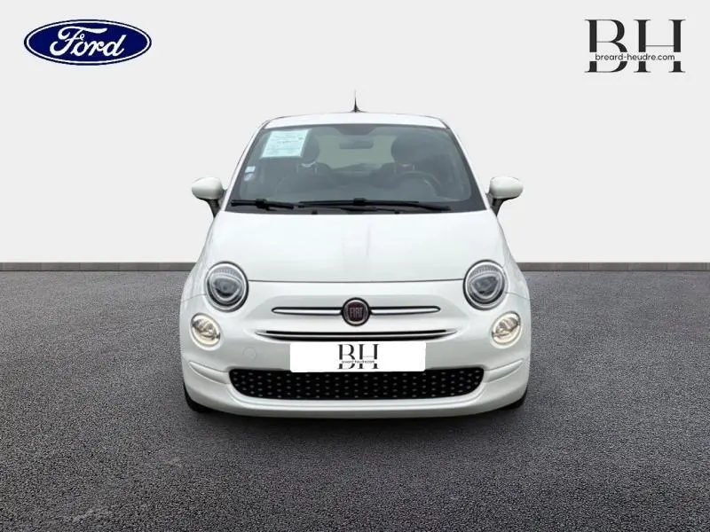 Vue frontale d'une Fiat 500 blanche Bossa Nova, avec calandre chromée et phares ronds allumés.