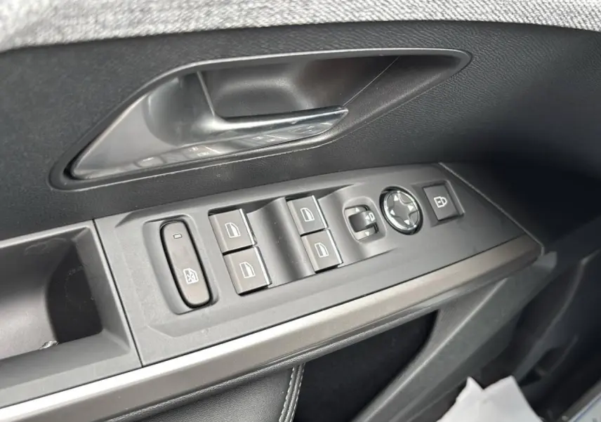 Gros plan sur la commande des vitres et rétroviseurs côté conducteur d’un Peugeot 3008 noir Perla, intérieur noir.