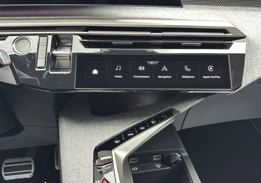 Vue rapprochée de la console centrale du Peugeot 3008 2026, écran tactile et commandes modernes sur fond tissu gris.