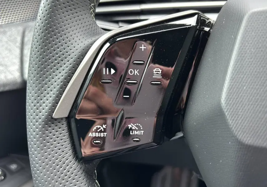 Gros plan sur les commandes noires du volant du Peugeot 3008 2026, avec boutons d'assistance et limitation de vitesse.
