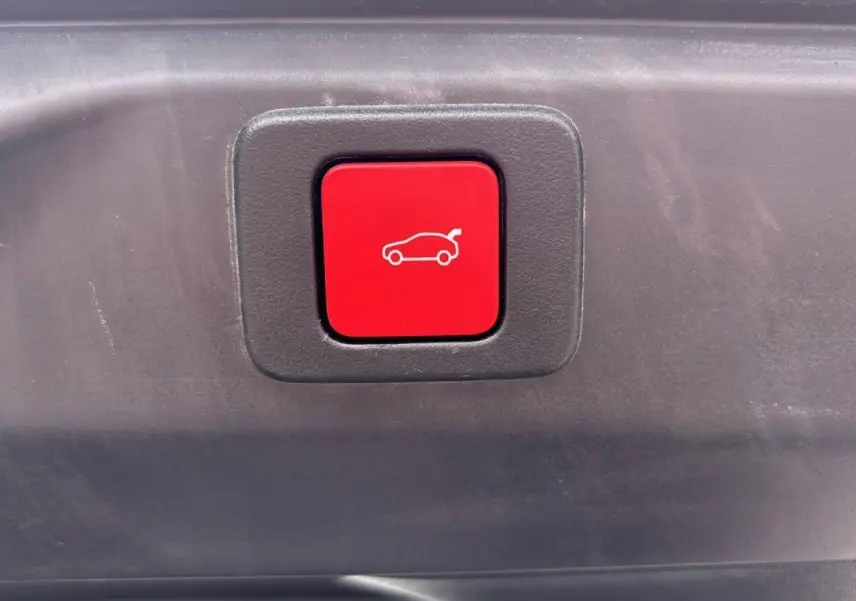 Bouton rouge d'ouverture électrique du hayon visible en gros plan sur Peugeot 3008 noir Perla 2026.