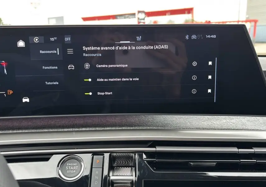 Écran tactile central du Peugeot 3008 2026 montrant les aides à la conduite, avec bouton start/stop et commandes de boîte auto.