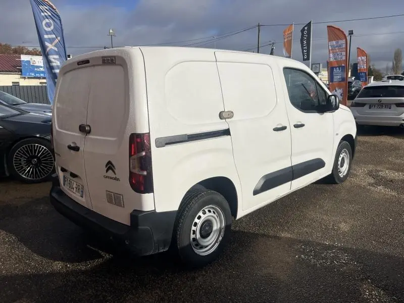 Vue 3/4 arrière droite d'un utilitaire Citroën Berlingo Fourgon blanc Banquise avec portes battantes arrière et porte latérale droite.