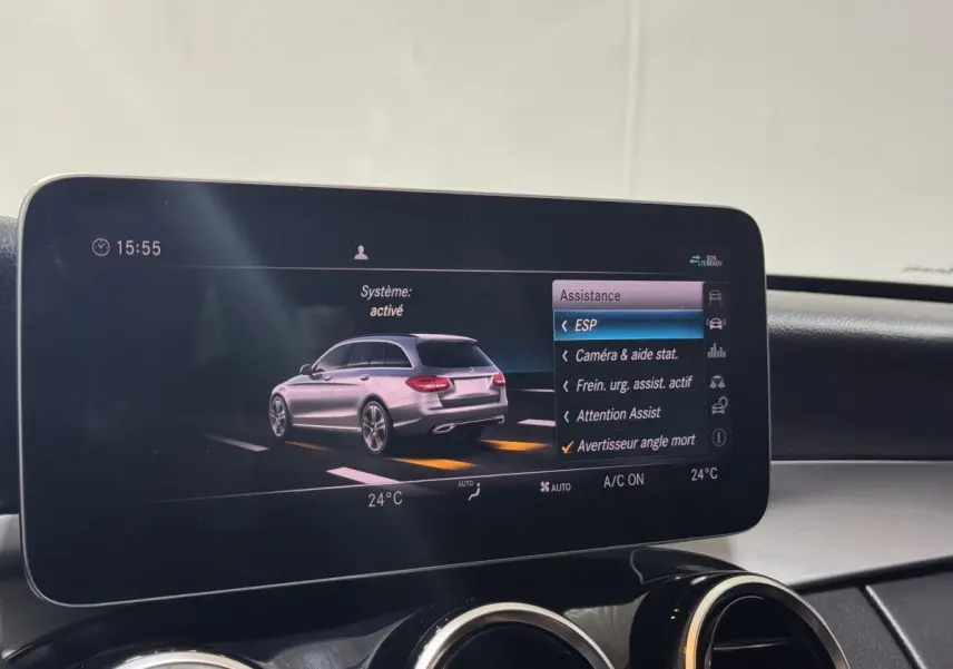 Écran central affichant l'aide à la conduite avec vue 3/4 arrière d'une Mercedes Classe C Break noire.