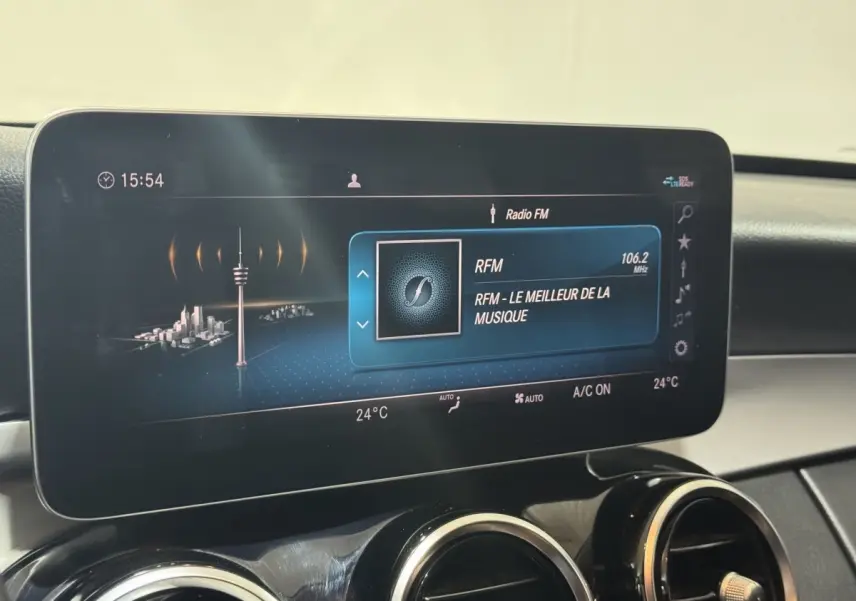 Écran tactile central affichant la radio FM dans l'habitacle d'une Mercedes Classe C Break noire de 2019