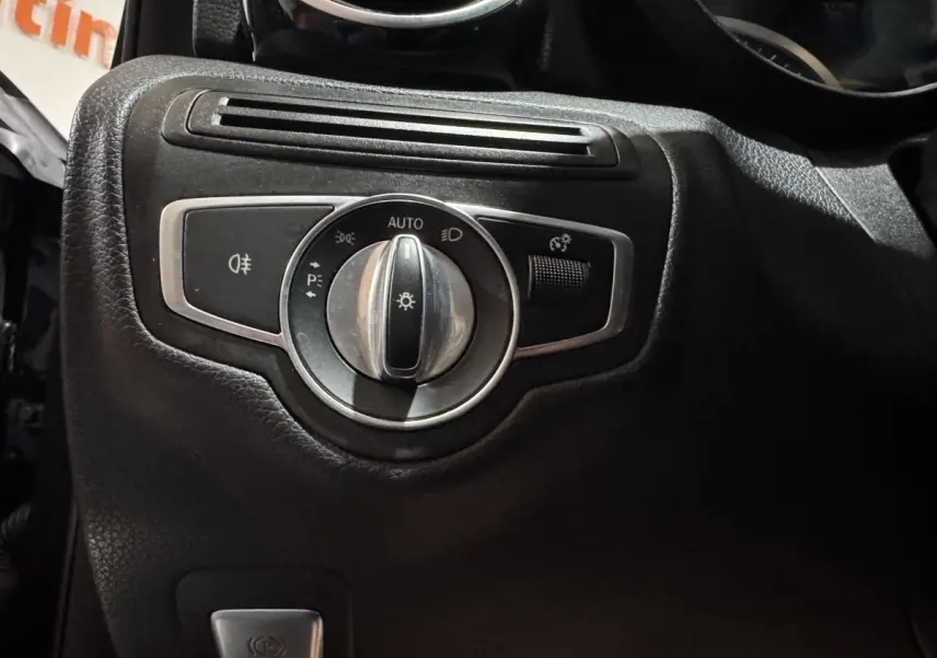 Gros plan sur le bouton de commande des phares dans l'habitacle noir du Mercedes Classe C Break C 200 d Business Line 2019.
