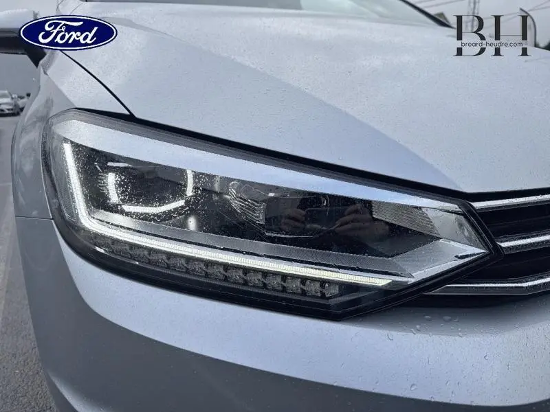 Gros plan sur le phare avant gauche du Volkswagen Touran 1.5 TSI EVO 2021 en Reflet d'Argent Métallisée.