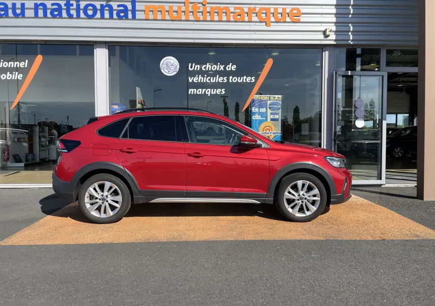 Volkswagen Taigo rouge roi vue de profil côté gauche, SUV compact avec jantes alliage et protections noires.