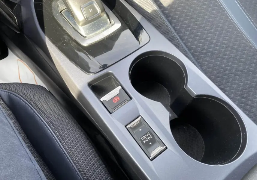 Gros plan sur la console centrale intérieure du Peugeot 2008 2020, montrant le frein de stationnement électrique et le sélecteur de mode de conduite.