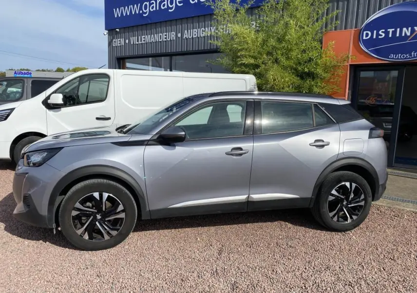 Peugeot 2008 gris clair vue de profil côté gauche, avec jantes noires et toit noir contrastant.