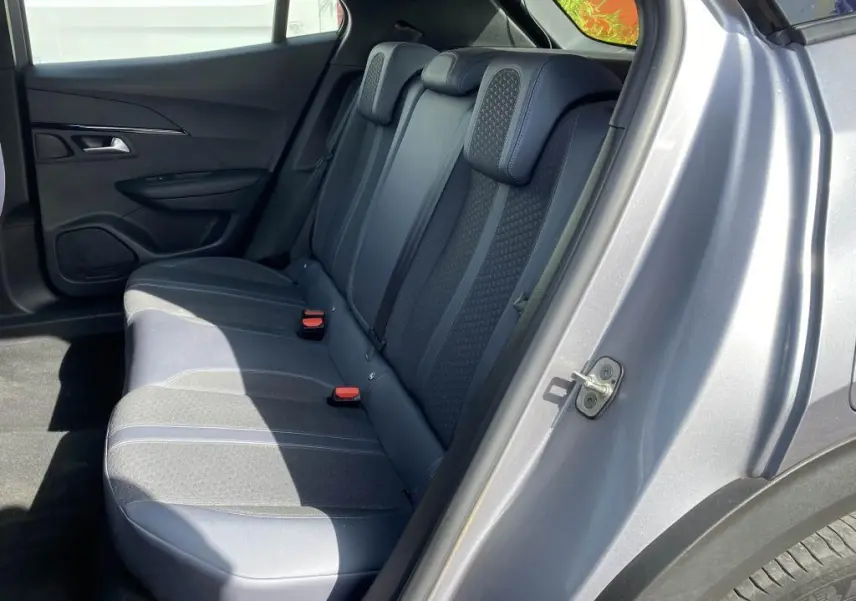 Vue côté droit arrière du Peugeot 2008 gris clair, montrant les sièges arrière en tissu et cuir avec appuie-têtes intégrés.