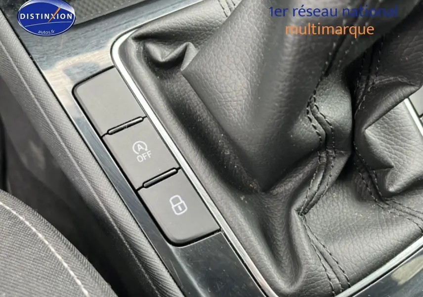 Gros plan sur la console centrale noire avec levier de vitesse cuir et boutons de commande de la Skoda Fabia blanche.