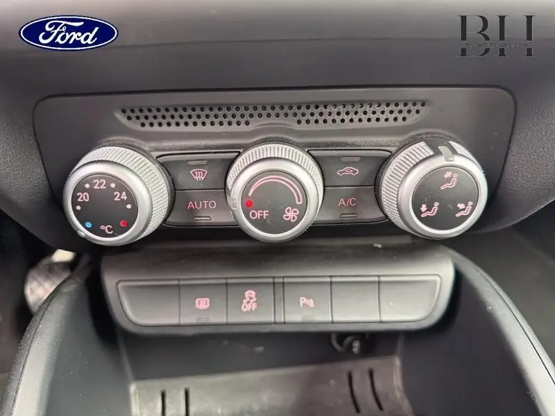 Gros plan sur les commandes de climatisation de l'Audi A1 Sportback noir brillant, avec réglages de température et ventilation.