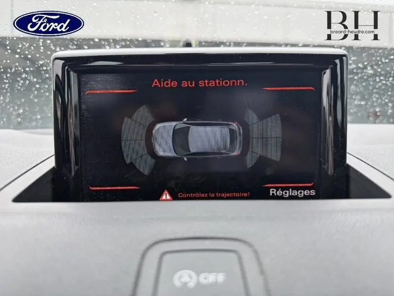 Écran central affichant l'aide au stationnement de l'Audi A1 Sportback noire, vue intérieure du tableau de bord.