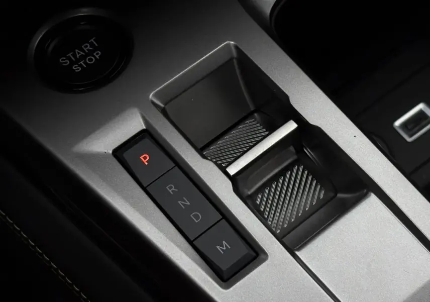 Gros plan sur la commande de boîte automatique et bouton start/stop dans l'intérieur gris aluminium du Peugeot 308 SW Hybrid.