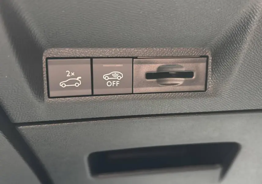 Boutons de commande du hayon électrique et de l'alerte de détection, vue rapprochée de l'intérieur noir du Peugeot 3008 GT hybride.