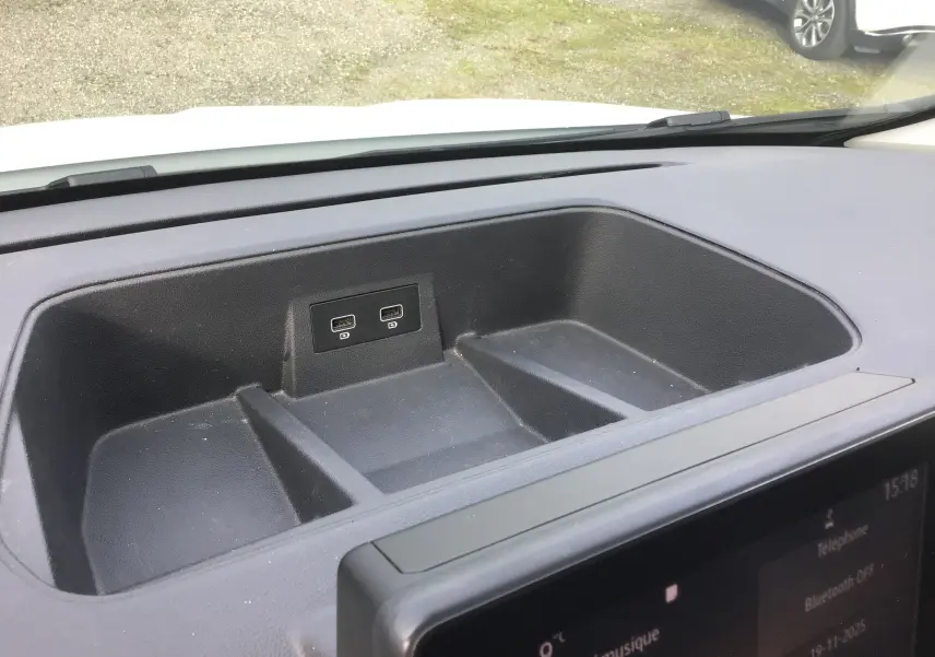 Rangement noir avec deux ports USB sur le tableau de bord du Renault Trafic Fourgon blanc, vue intérieure avant.