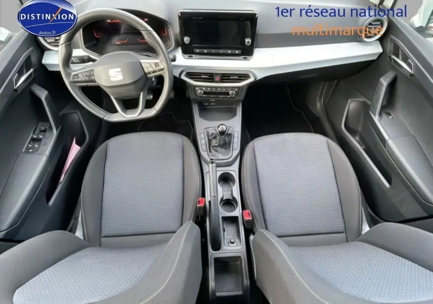 Vue intérieure de face du poste de conduite de la SEAT Ibiza 1.0 TSI 95 Copa avec sièges tissu gris et volant cuir multifonction.
