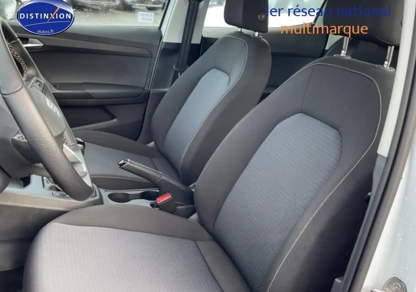 Vue intérieure côté conducteur montrant les sièges tissu gris de la SEAT Ibiza 1.0 TSI 95 Copa blanche Nevada.