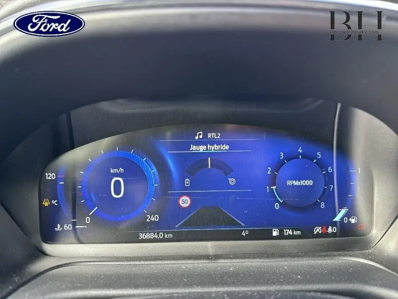 Tableau de bord numérique bleu du Ford Puma 1.0 EcoBoost 125ch, affichage vitesse, compte-tours et jauge hybride.