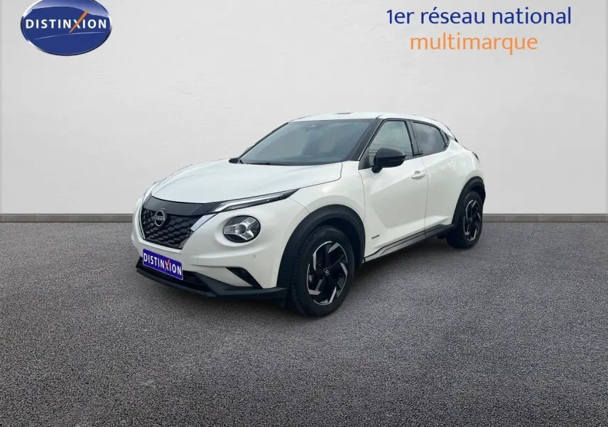 Nissan Juke blanc nacré métal en vue 3/4 avant droit, avec jantes noires et toit contrasté noir.