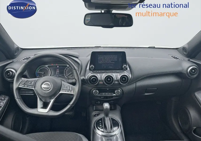 Intérieur noir du Nissan Juke 2024, vue frontale du tableau de bord avec écran tactile et volant multifonction.