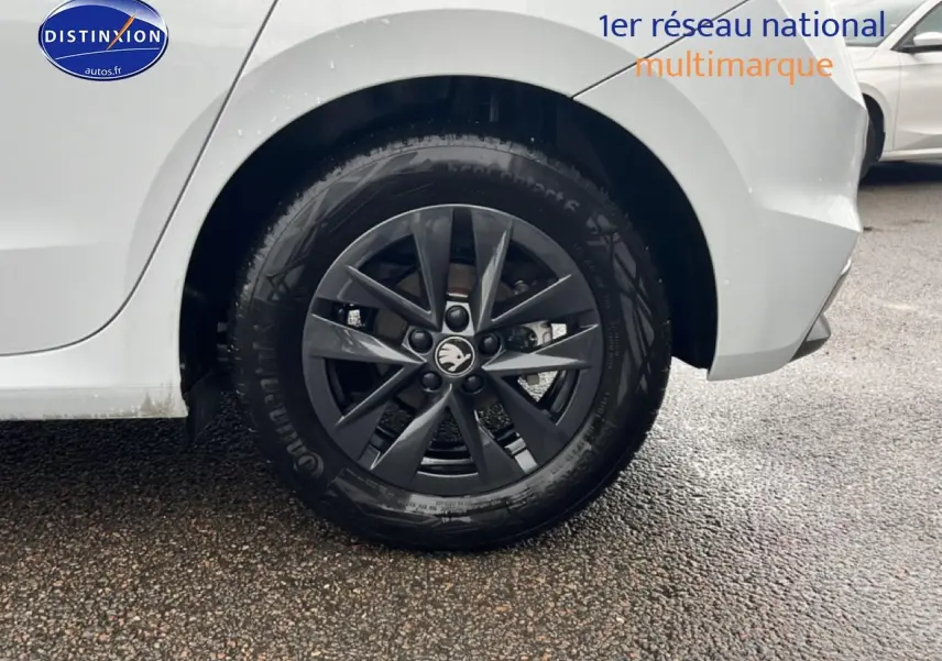 Gros plan sur la roue arrière droite d'une Skoda Fabia blanche avec jante alliage gris foncé.