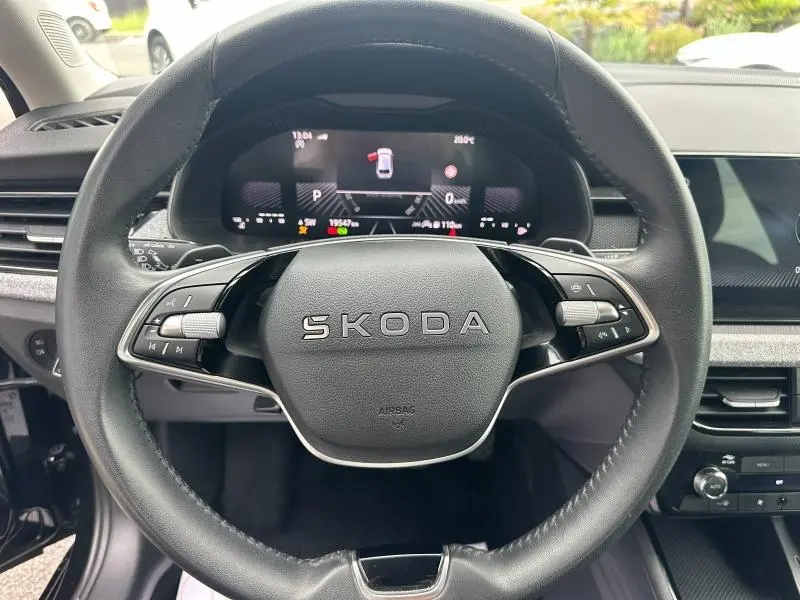 Vue rapprochée du volant cuir multifonction Skoda SCALA 2025 avec tableau de bord numérique et commandes intégrées.