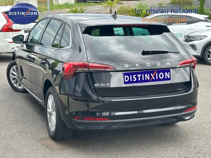 Vue 3/4 arrière droite d'une Skoda Scala noire Magic nacré avec feux arrière LED et jantes alu.