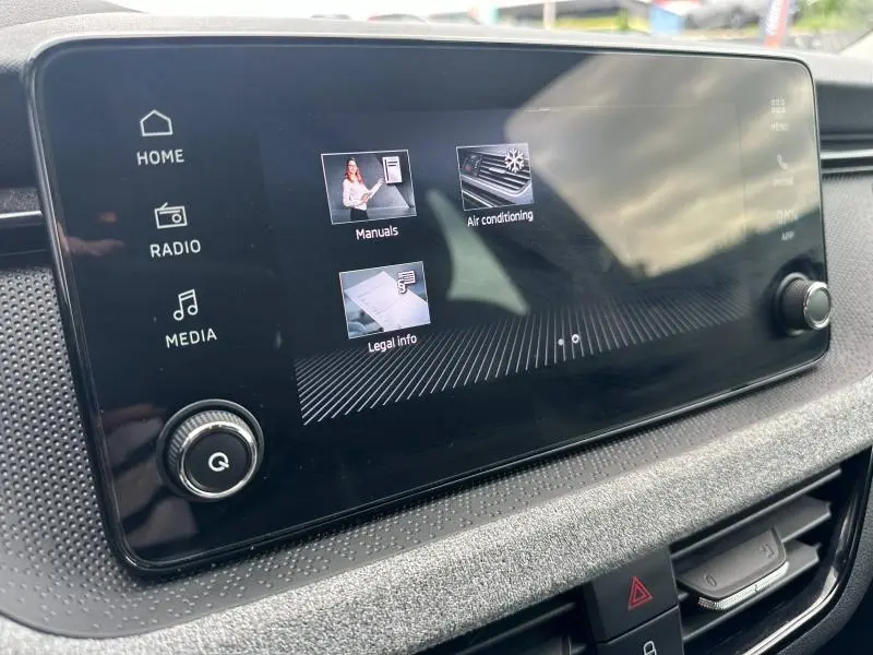 Écran tactile central en gros plan dans l'habitacle du Skoda Scala noir Magic nacré, affichant le menu principal.