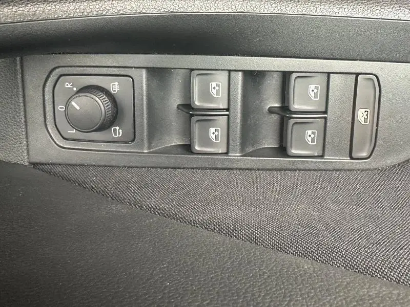 Vue rapprochée des commandes de lève-vitres et réglage des rétroviseurs sur la porte côté conducteur d'une Skoda Scala noir nacré.