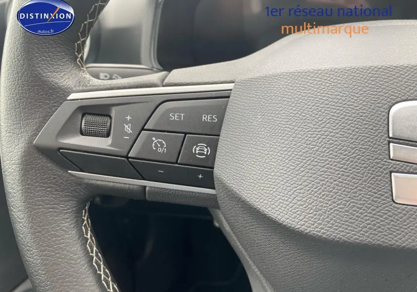 Gros plan sur le volant cuir noir de la SEAT Ibiza 2025 avec commandes multifonctions côté gauche.