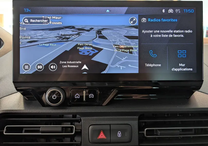 Écran tactile central du Peugeot Rifter 2025 affichant la navigation 3D et les options radio, avec commandes sous l'écran.