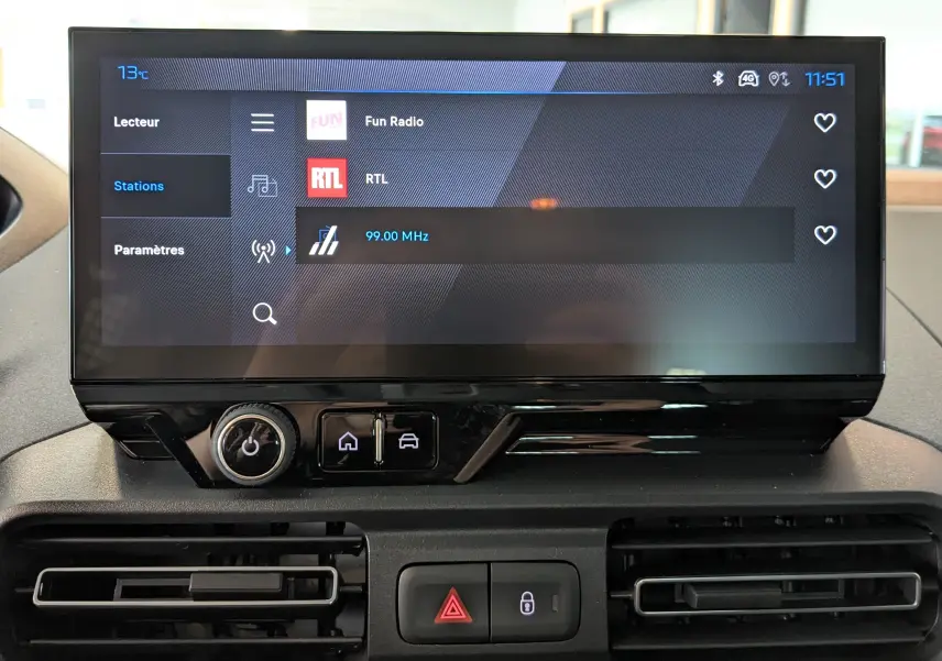 Écran tactile central du tableau de bord du Peugeot Rifter 2025, affichant les stations radio avec interface moderne.
