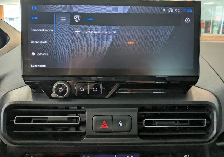 Écran tactile central du Peugeot Rifter 2025 gris Artense, vue rapprochée du tableau de bord avec commandes et aérateurs.