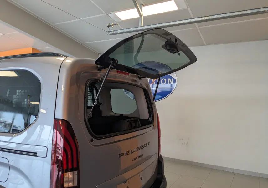Vue arrière droite du Peugeot Rifter gris Artense 2025 avec hayon vitré ouvert, mettant en valeur les feux arrière verticaux.