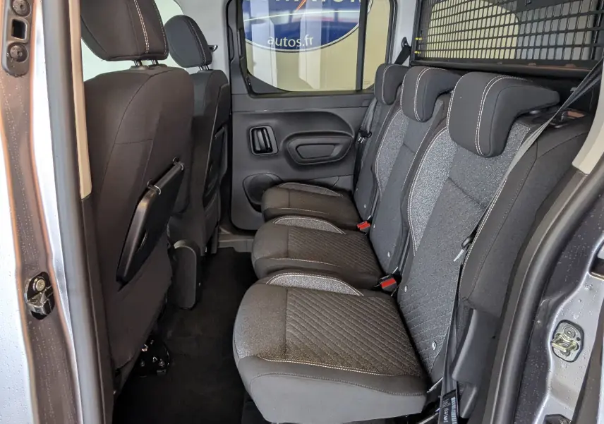 Vue intérieure côté droit montrant la banquette arrière trois places en tissu gris du Peugeot Rifter gris Artense 2025.