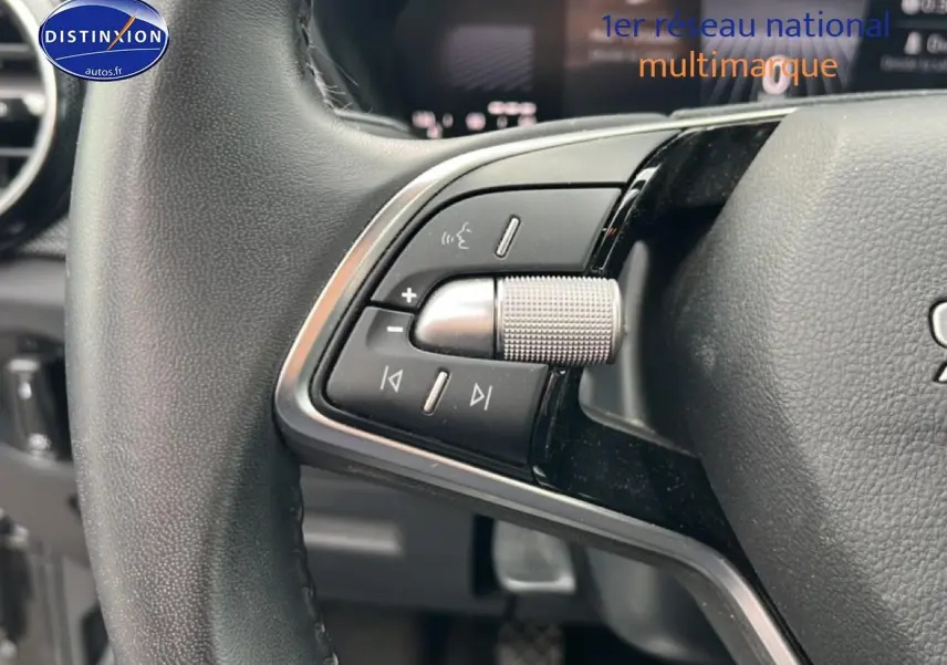 Gros plan sur les commandes audio et vocales au volant cuir noir de la Skoda Fabia 2025.