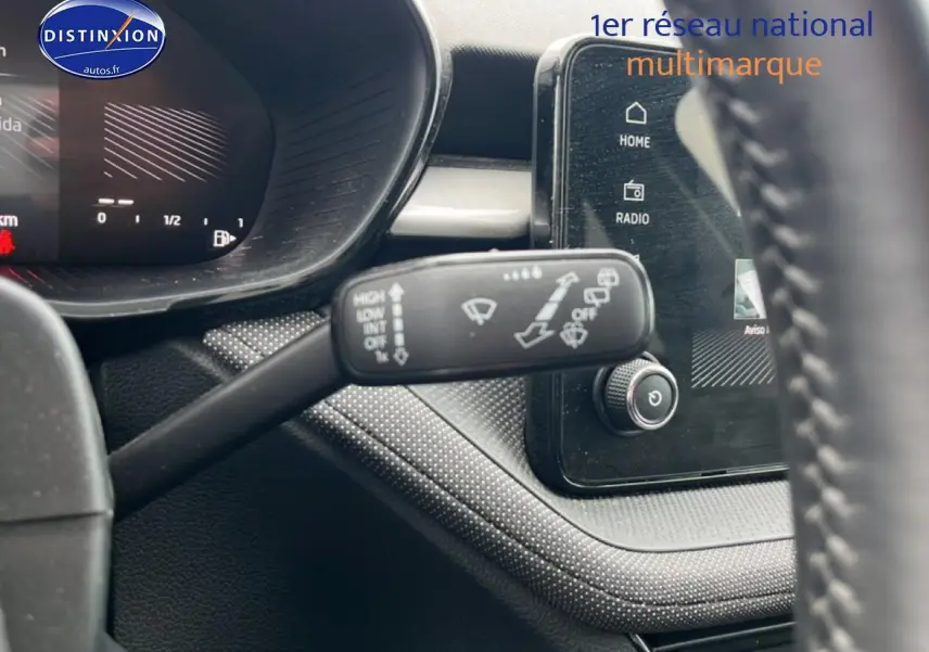 Vue rapprochée du commodo d’essuie-glace et de l’écran tactile du tableau de bord d’une Skoda Fabia noire 2025.