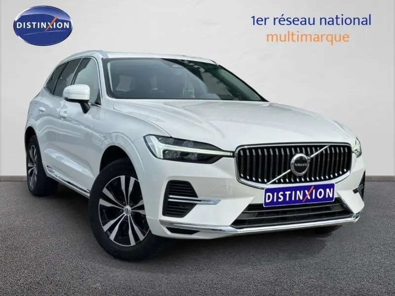Vue 3/4 avant d'un Volvo XC60 blanc cristal métallisé avec calandre chromée et jantes alliage noires et argent.