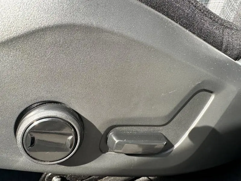 Détail des commandes de réglage électrique du siège côté gauche dans un Volvo XC60 blanc cristal métallisé 2024.