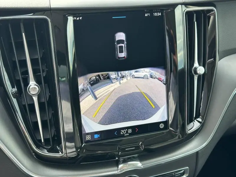 Écran tactile central affichant la caméra de recul du Volvo XC60 blanc, entouré de la console noire brillante.